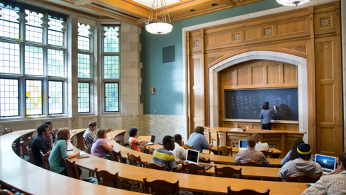 A professor gives a lesson to a lecture hall full of students